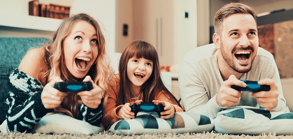 Family of 3 people playing playstation games at home - Broadband for families