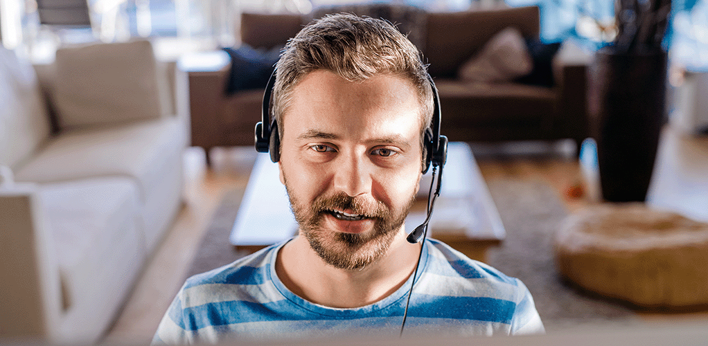 Man working from home with a headset on using full fibre from Jurassic Fibre