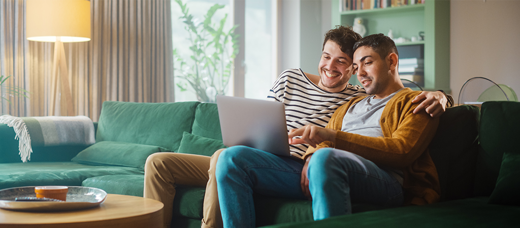 two people enjoying streaming a movie on a laptop at home with broadband supplied by Jurassic Fibre