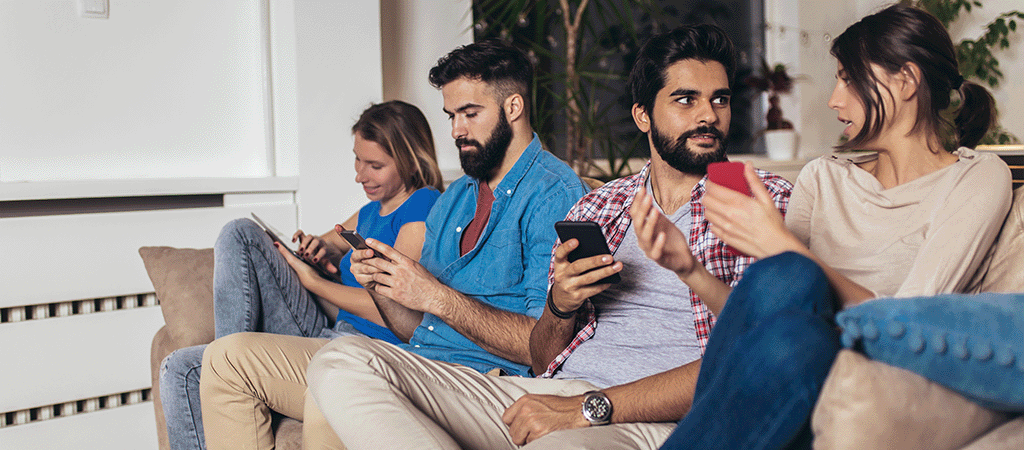 Family sitting on the sofa on their smart phones