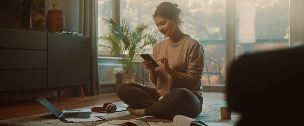 Person sat on floor in house on mobile with broadband